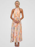Woman wearing the breezy Cordelia halter midi dress with a soft watercolor floral print